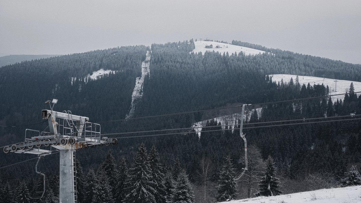 Snow-covered pine ridge above a Ukrainian ski resort with chairlift pylons in the foreground